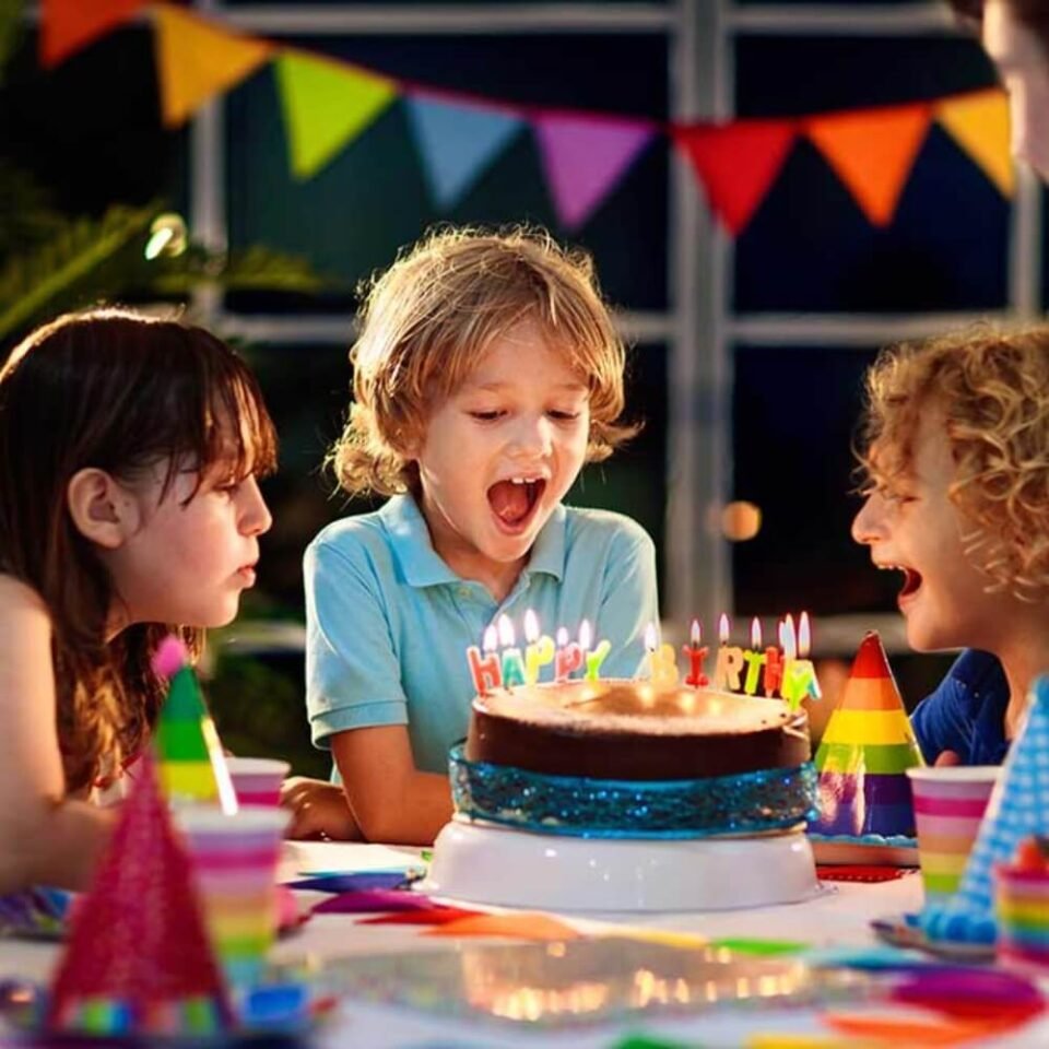 Laimīgs vīrietis un bērni svin dzimšanas dienu ar smaidiem un baloniem